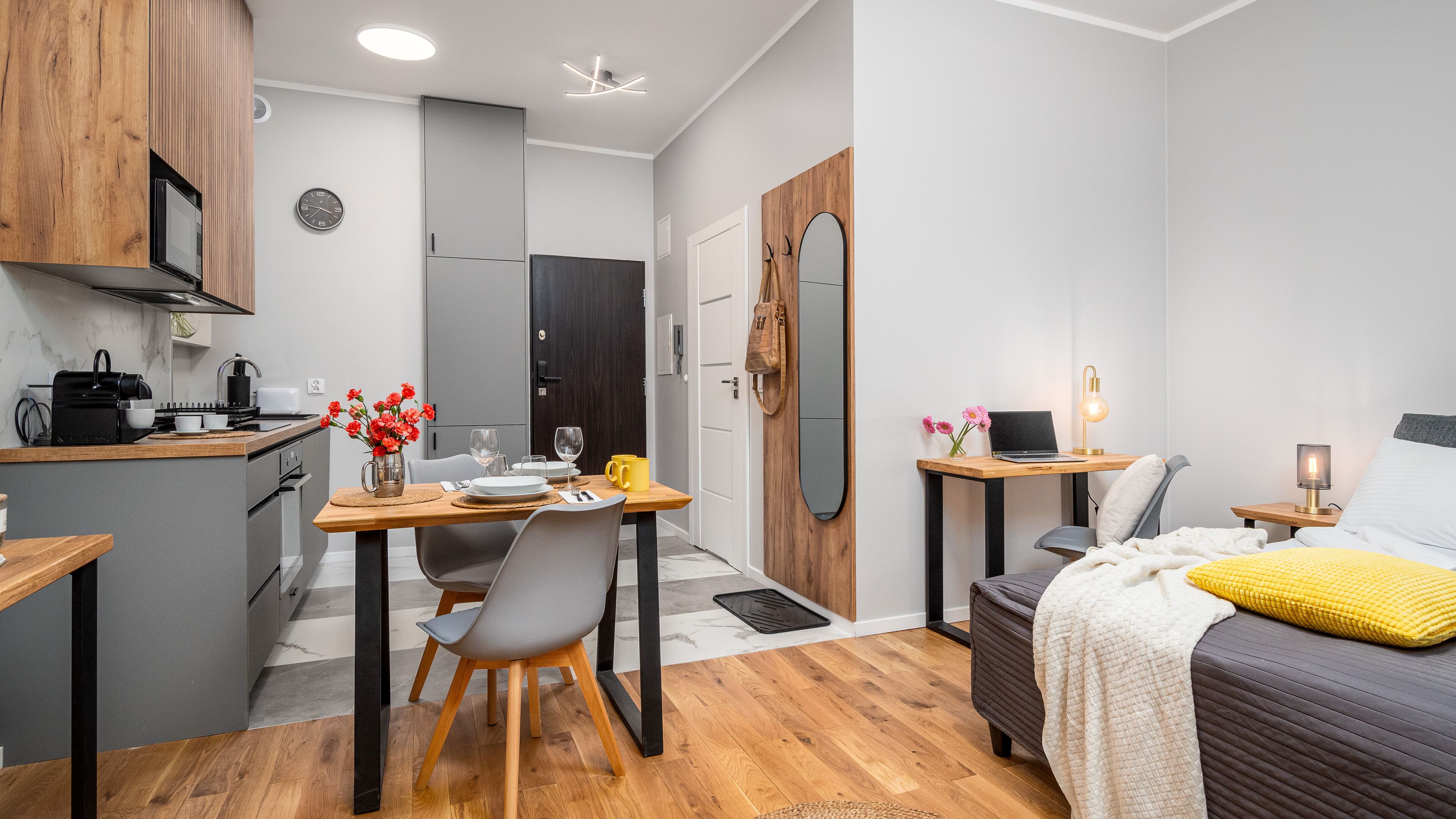 Quarto de hotel compacto com cozinha compacta, área de refeições, espaço de trabalho e uma cama.