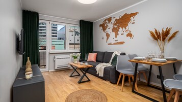 Una sala de estar moderna con un sofá, una mesa de comedor y un mapa del mundo en la pared.