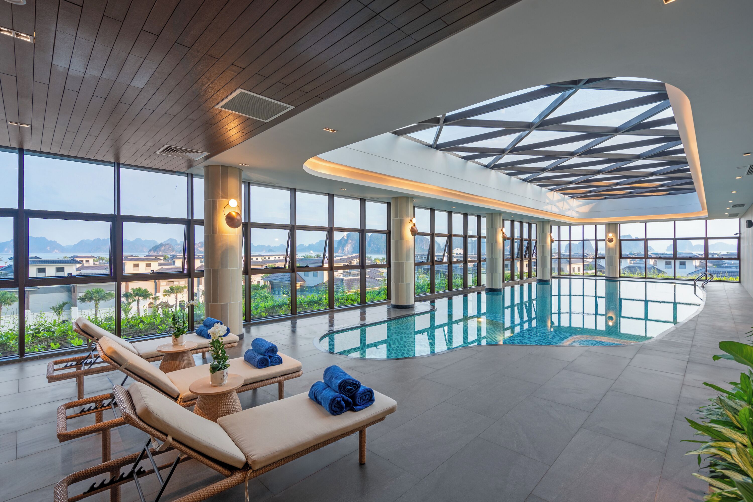 Ein moderner Innenpool mit Liegestühlen und Blick auf die Berge.