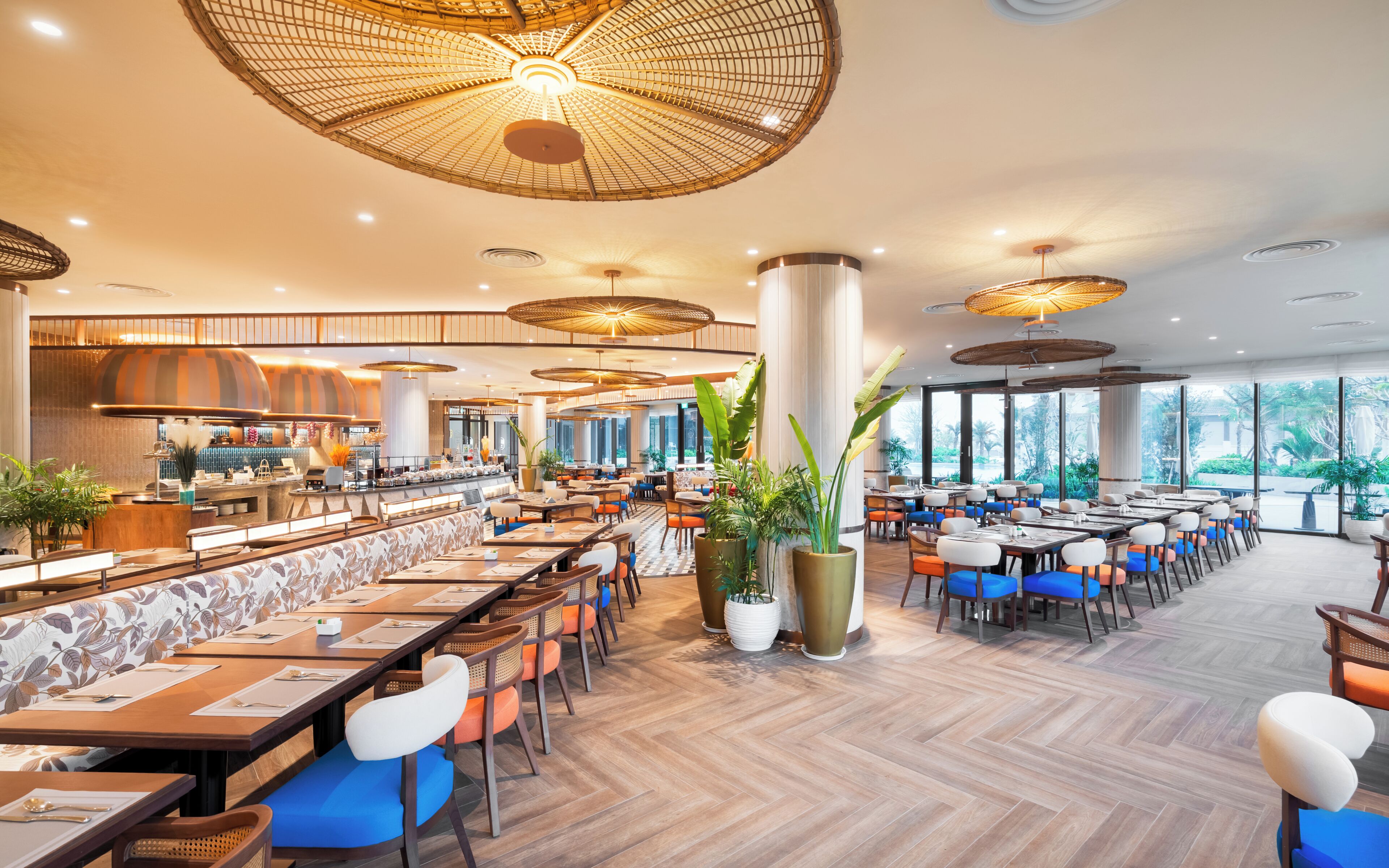 Ein geräumiges Restaurant mit hohen Decken, großen Fenstern und unterschiedlichen Sitzmöglichkeiten.