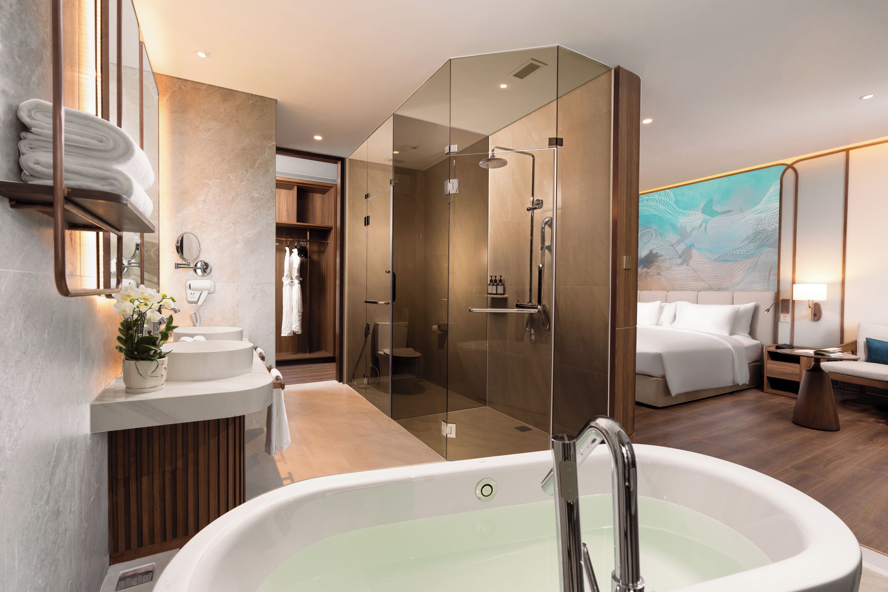 A modern bathroom with a large bathtub, a glass-enclosed shower, and a vanity with a mirror and towel rack.