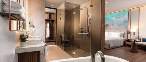 A modern bathroom with a large bathtub, a glass-enclosed shower, and a vanity with a mirror and towel rack.