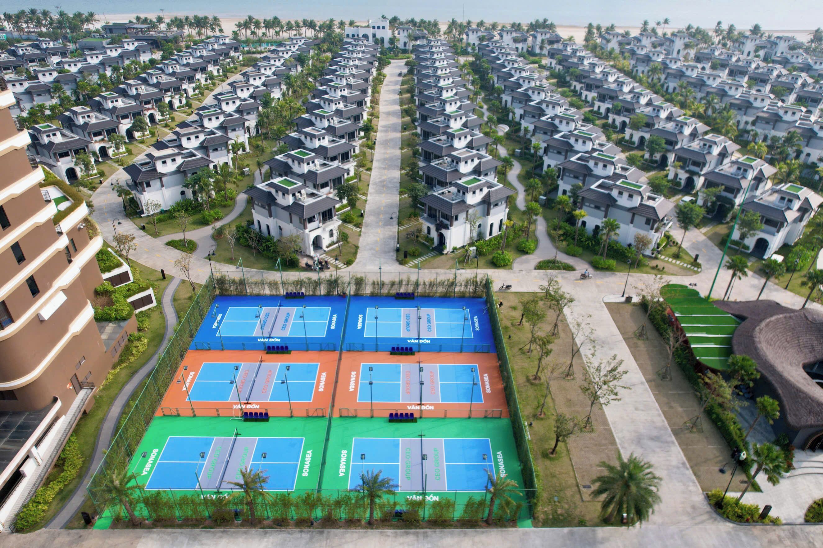 A residential area with multiple apartment buildings, a tennis court, and a distinctive curved building.