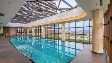 Een binnenzwembad, 2 buitenzwembaden en parasols bij het zwembad