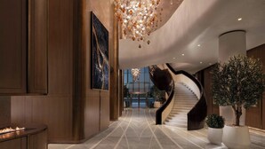 A modern lobby with a marble floor, a large abstract painting, a unique spiral staircase, and a fire feature. - The St. Regis Belgrade (Belgrade)