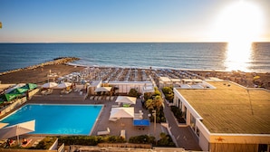 A resort with a swimming pool, beach area, and ocean view. - Hotel Stella Marina (Cecina)