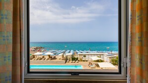 A view of a beach resort with a swimming pool, beach umbrellas, and lounge chairs. - Hotel Stella Marina (Cecina)