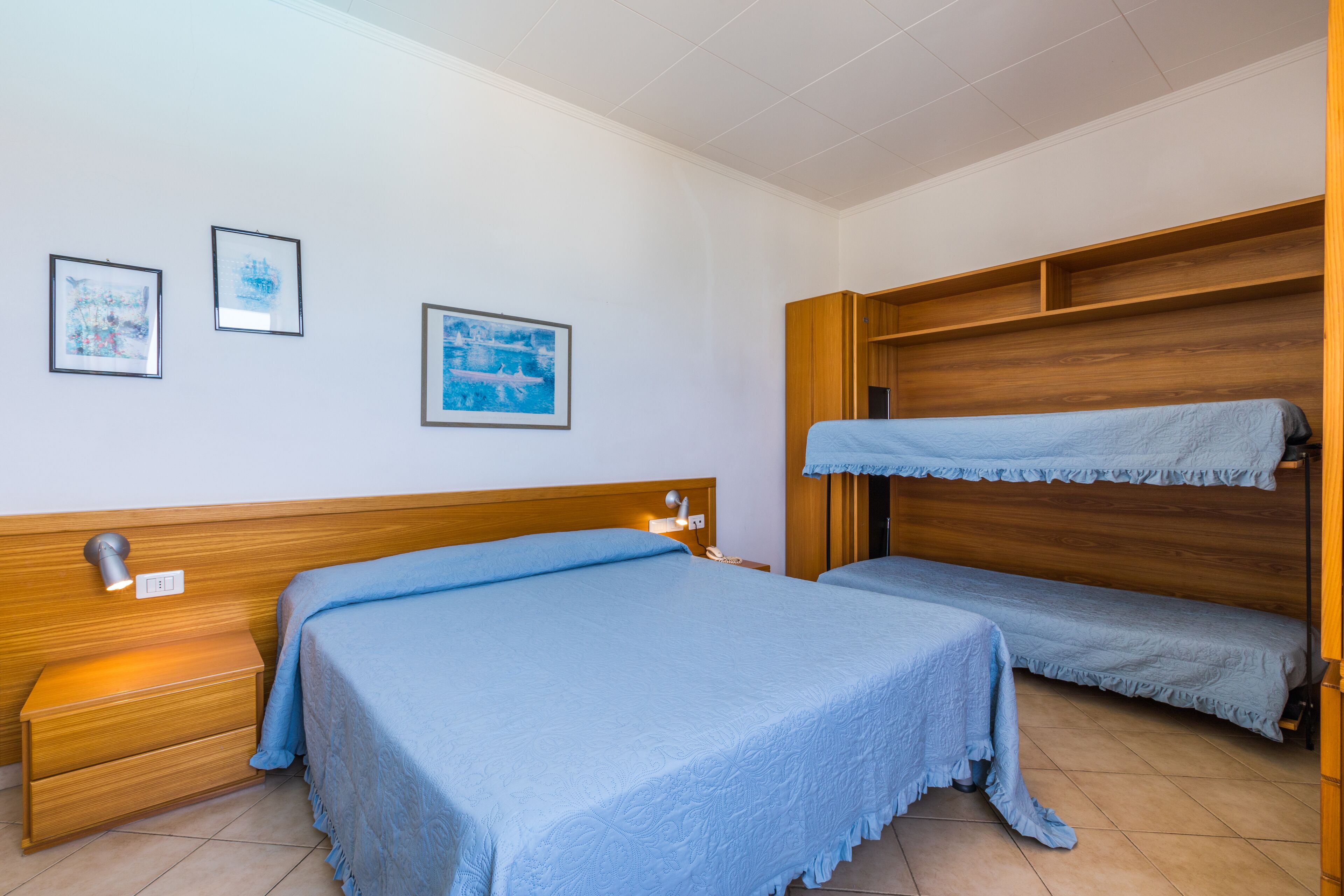 Un dormitorio con dos camas, cabeceros de madera y obras de arte colgadas en la pared.
