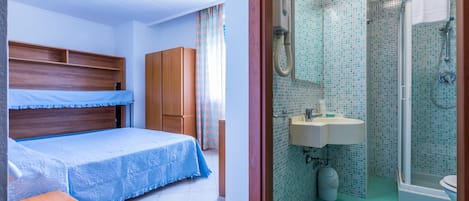 A bedroom with a bed, a wardrobe, and a desk. The room has a window with curtains.