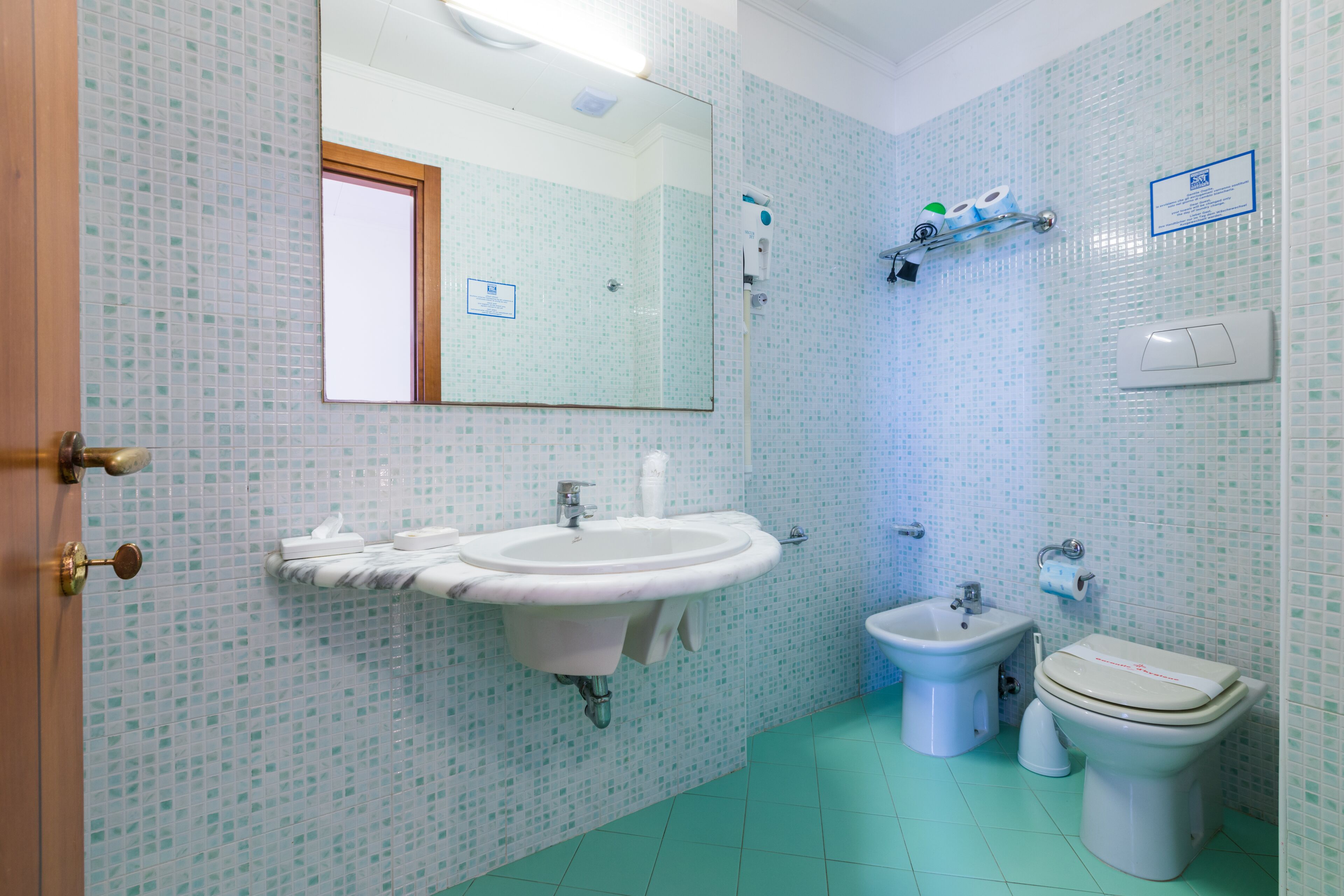 Un baño con lavamanos, bidé e inodoro.