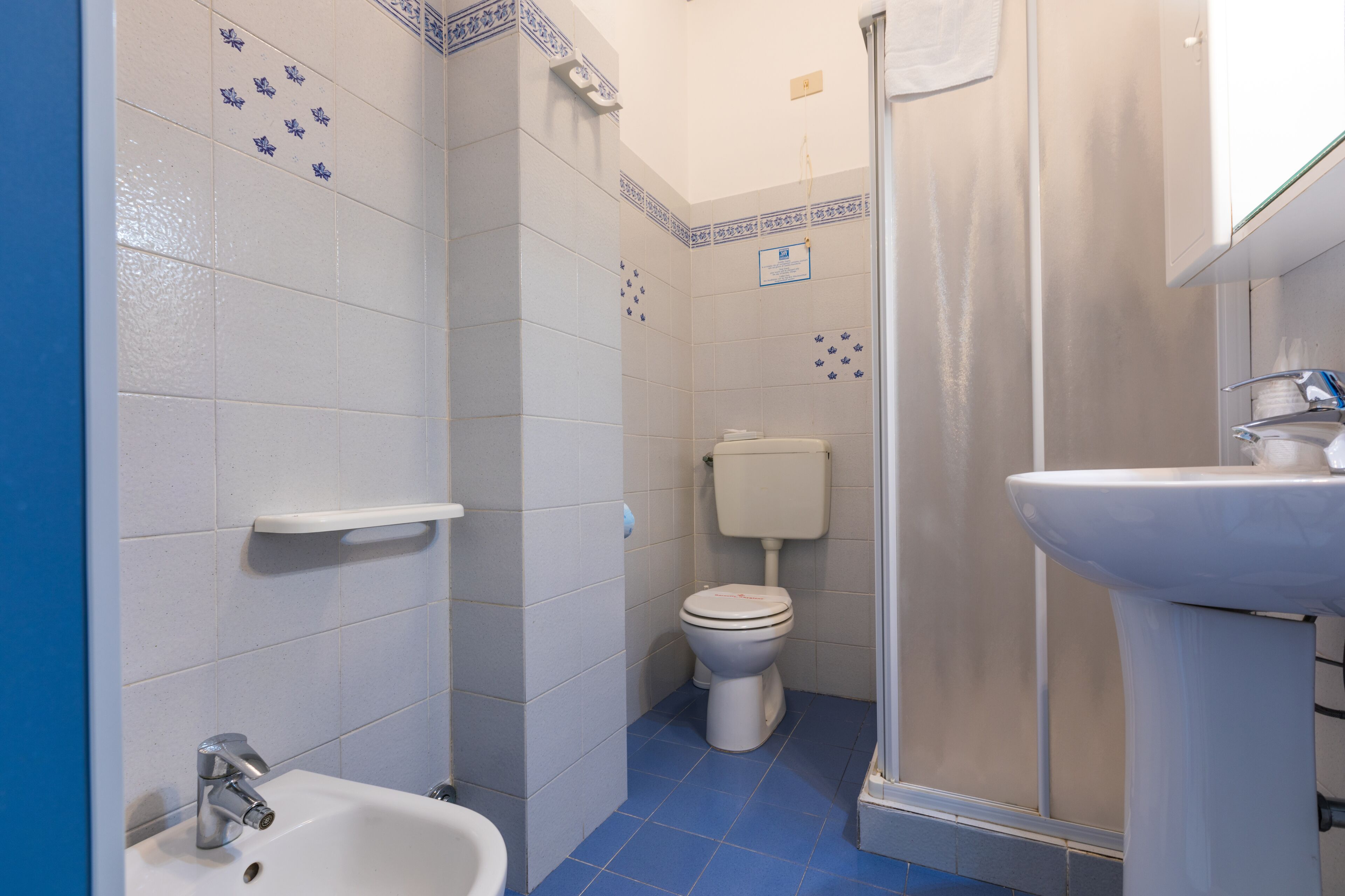 A bathroom with a toilet, sink, and shower.