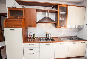 Una cocina compacta con estufa, lavamanos y armarios de madera.