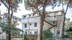 Ein begrenzter Zugang zu einem Wohngebiet, mit einem Feldweg, der zu einem Gebäude mit einer Treppe führt.