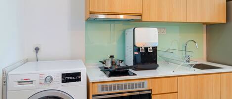 Una cocina compacta con lavadora Bosch, cafetera y lavavajillas.