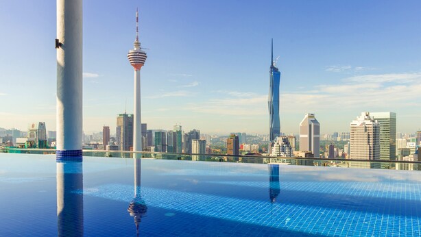 Piscina infinita no terraço, com o horizonte da cidade ao fundo.