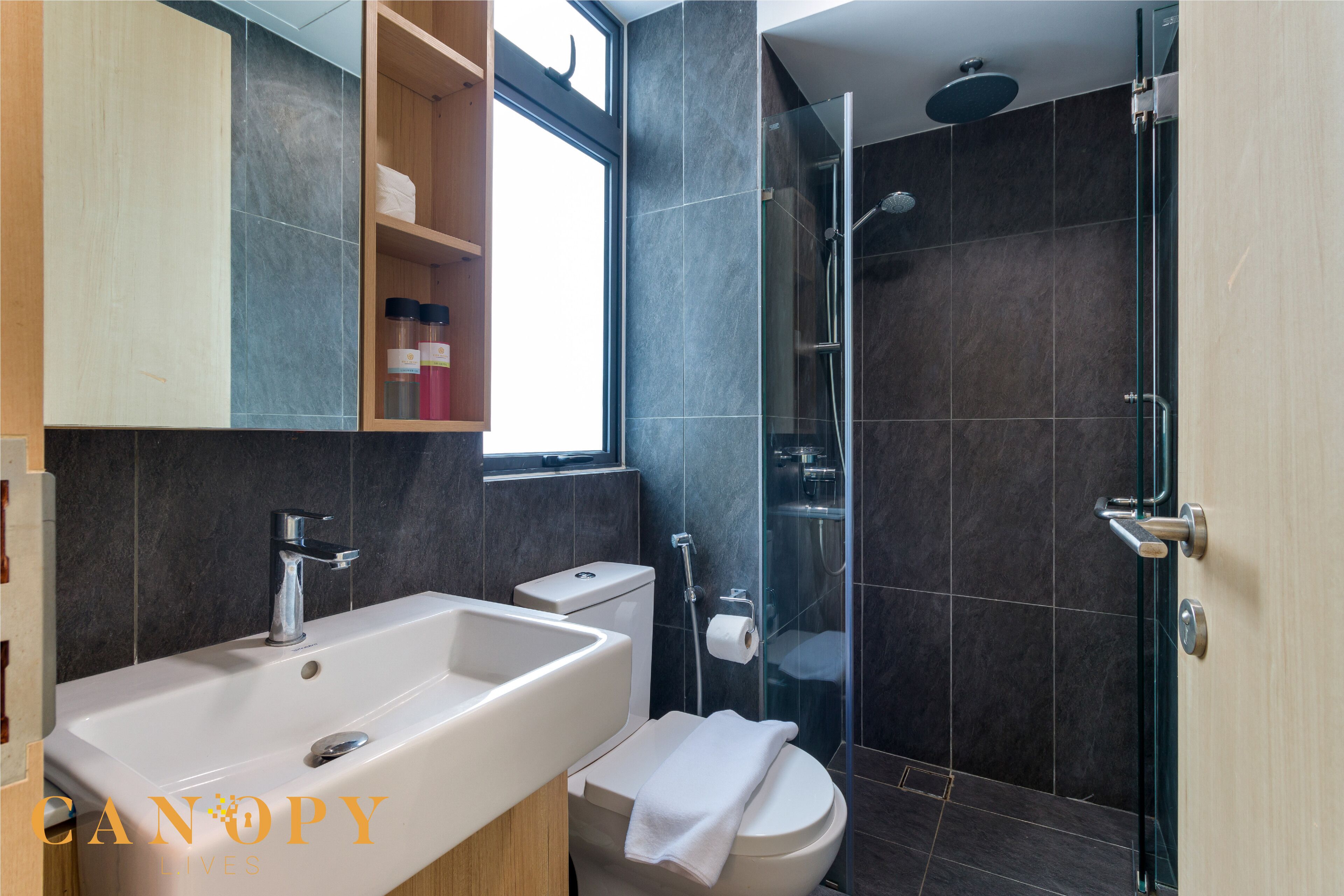 A modern bathroom with a large sink, toilet, and shower area.