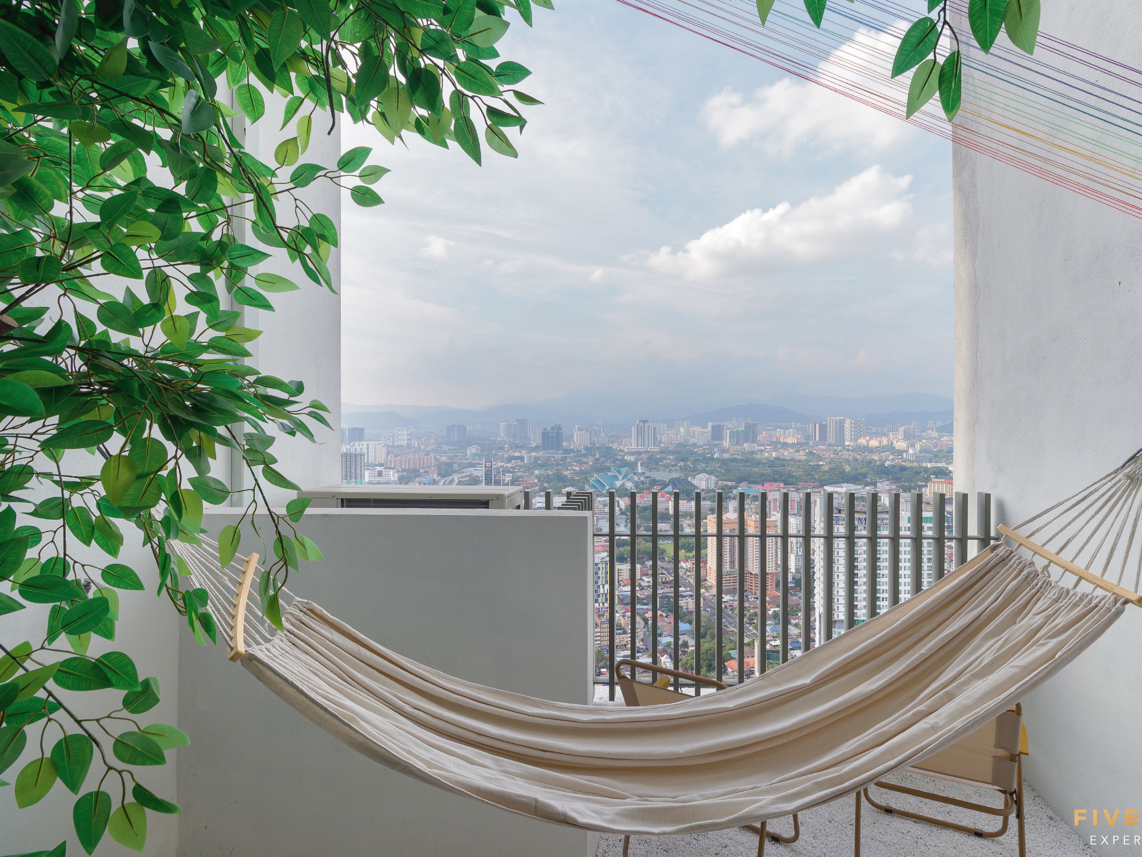 Una hamaca en un balcón con vista a la ciudad.