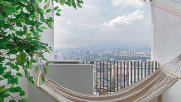 Una hamaca en un balcón con vista a la ciudad.