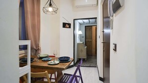 Un comedor con una mesa de madera, sillas y una lámpara colgante.