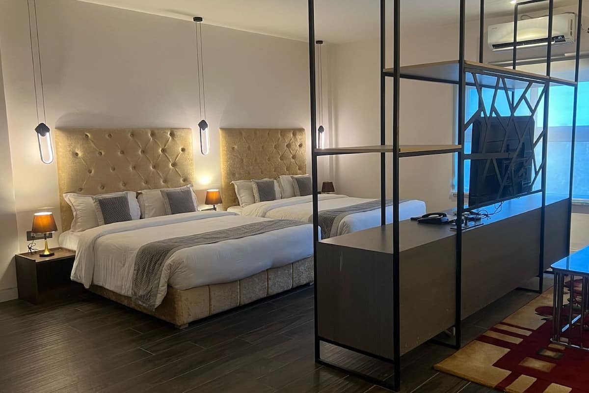 Une chambre d’hôtel moderne, dotée d’un grand lit, d’un bureau et d’une télévision.