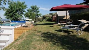 A backyard with a swimming pool, lounge chairs, and a covered seating area. - Rustikale Villa mit Privat Pool in Buti, Toscana. Haustierfreundlich (Buti)