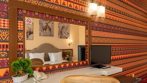 A hotel room with a large mirror, a bed, a TV, a telephone, and a small table with a plant. - Allegra Balneo & SPA (Golden Sands)
