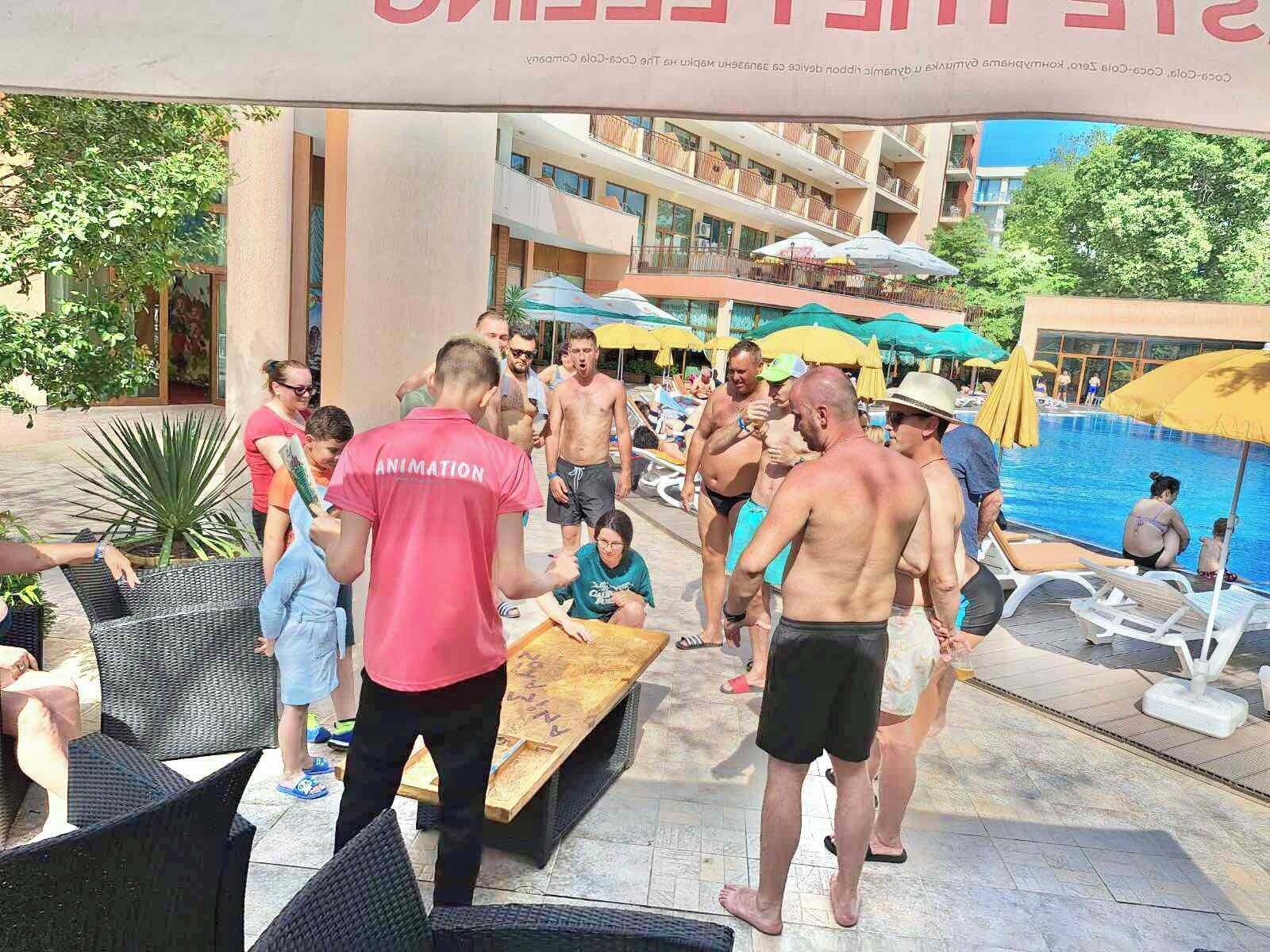A poolside area with lounge chairs, umbrellas, and people relaxing.