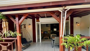 A covered outdoor area with a wooden structure, a hanging chair, and potted plants. - Villa Simeon Saint Francois Avec Piscine Privee ET Jacuzzi Proche Plage Tarif Light (Saint-François)