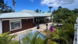 A house with a pool, surrounded by palm trees and greenery. - Villa Simeon Saint Francois Avec Piscine Privee ET Jacuzzi Proche Plage Tarif Light (Saint-François)