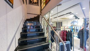 Una escalera que lleva a una tienda de ropa con escaparate de vidrio.