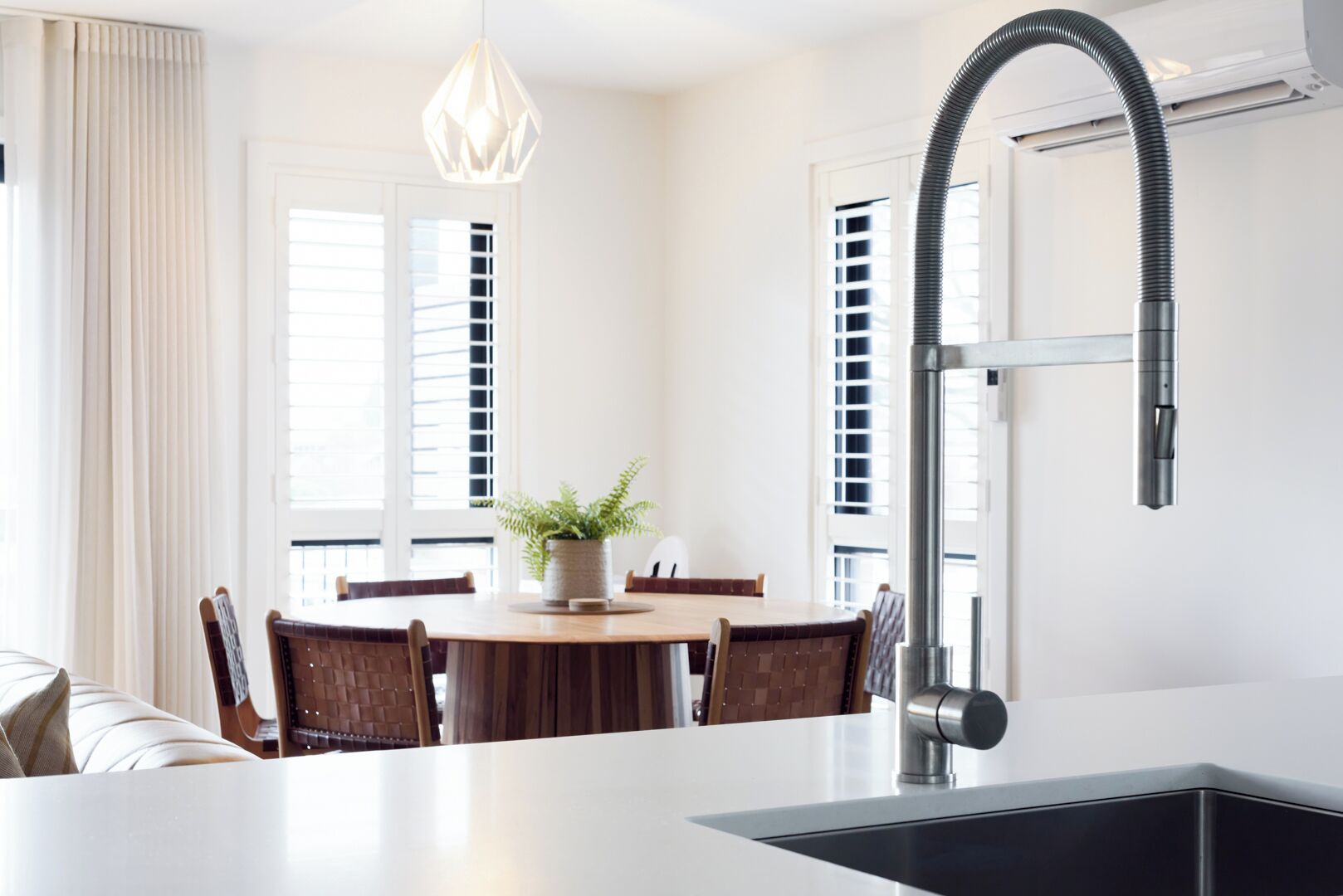 A modern kitchen with a large island, a built-in sink, and a pendant light.