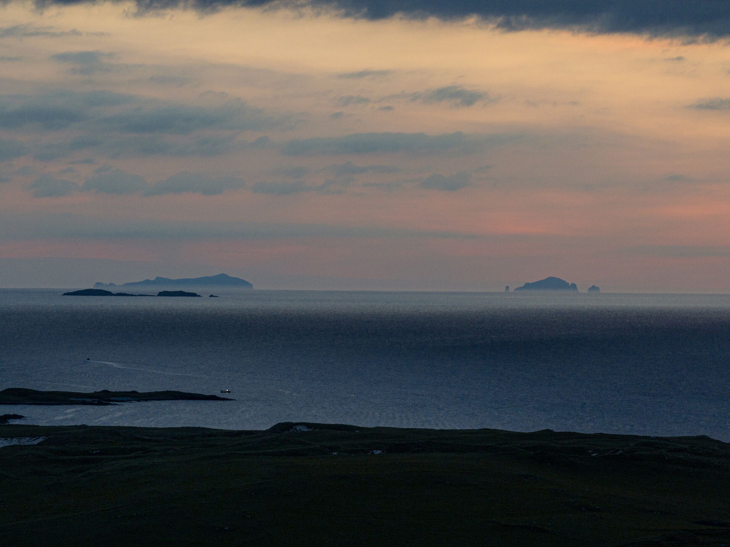 A coastal landscape with a view of the sea and distant islands.