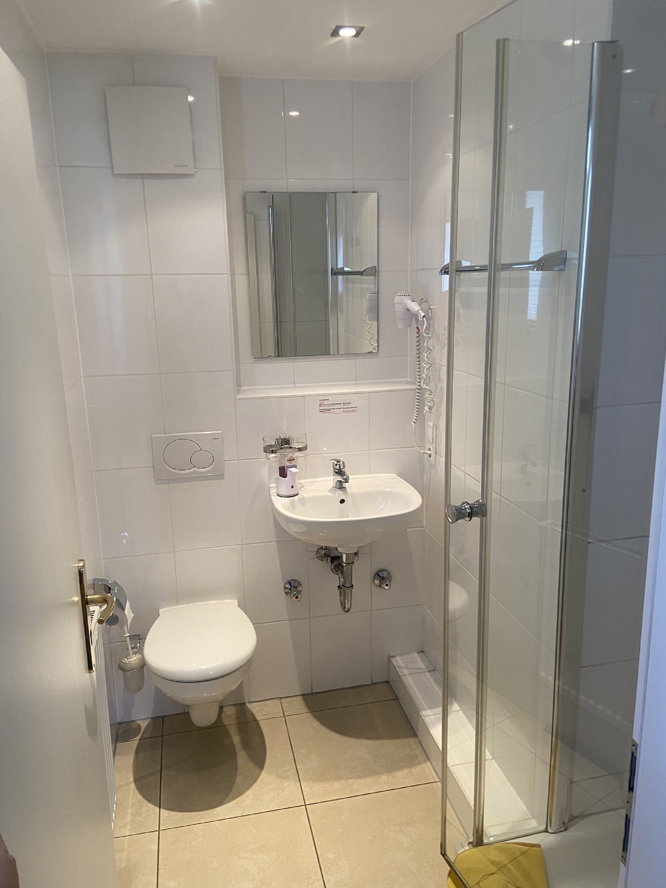 Ein kleines Badezimmer mit Toilette, Waschbecken und Duschkabine.