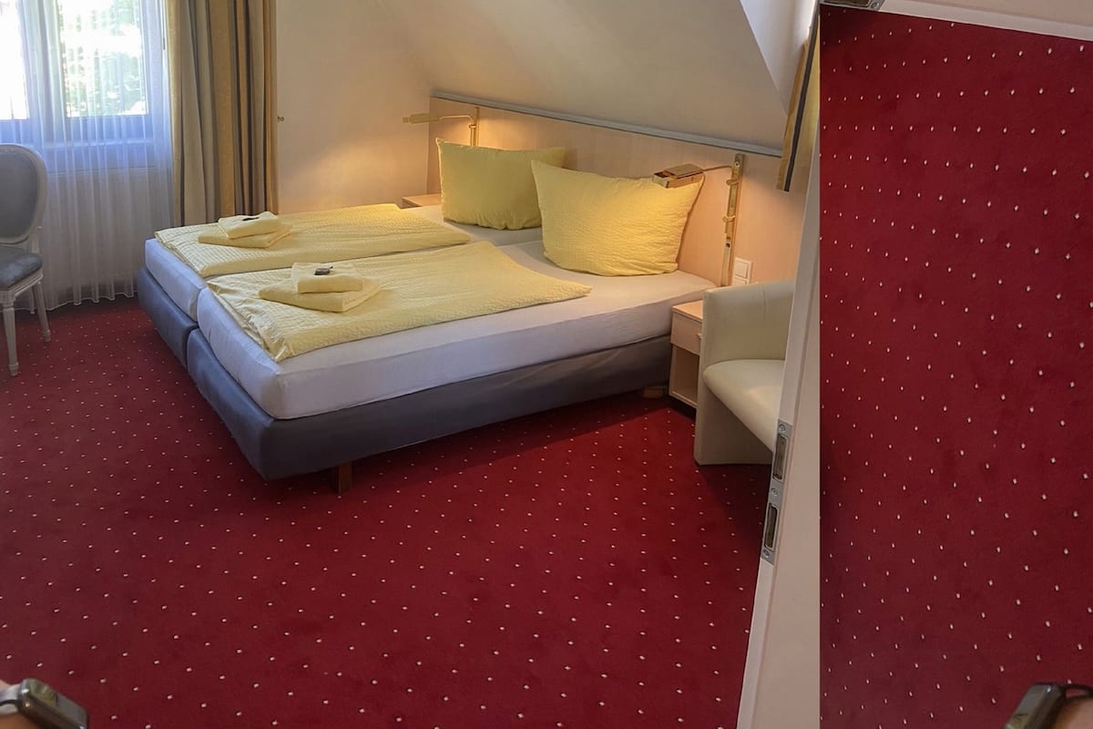 A hotel room with a bed, a chair, and a desk.