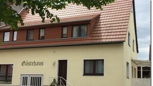 Un edificio con techo de tejas y un letrero que dice "Gästehaus".