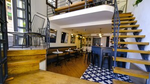 A multi-level restaurant with wooden floors, a staircase, and a mix of seating areas including tables and chairs. - Hostel Le Banc (Istanbul)