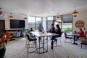 A modern meeting room with large windows, a flat-screen TV, and a variety of seating options. - Cowool Toulouse (Toulouse)