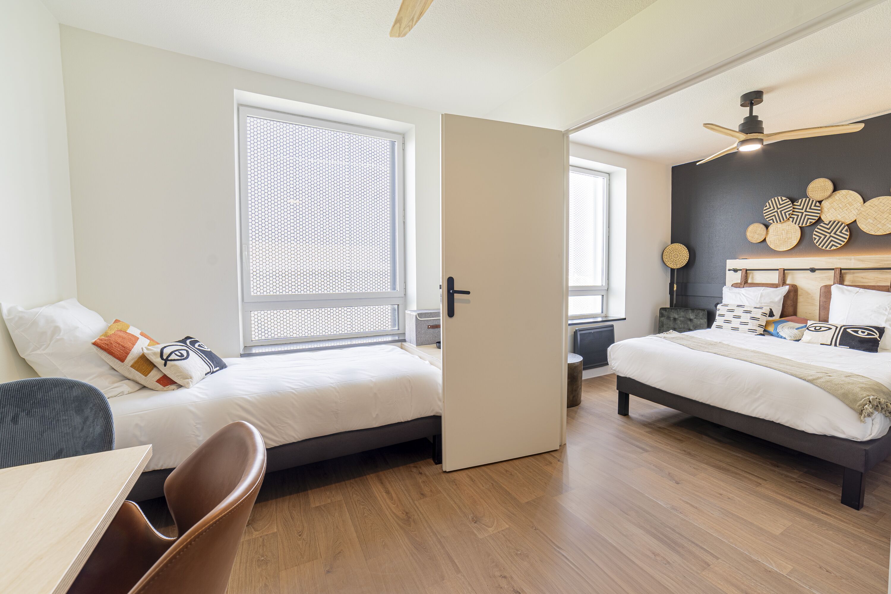 Un dormitorio moderno con dos camas, un escritorio y una silla.