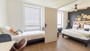 Un dormitorio moderno con dos camas, un escritorio y una silla.