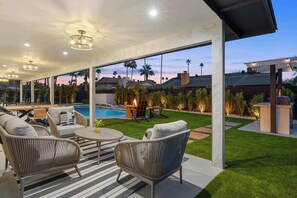An outdoor patio with a pool, wicker furniture, and a view of the neighborhood. - Valley View: Chic Design w/ Pool, Grille, Firepit (Scottsdale)