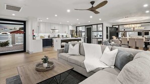 Un salon moderne avec un canapé, une table basse agrémentée d’une plante et un ventilateur de plafond.