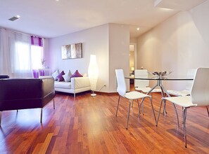 A modern living room with a sofa, a glass dining table with chairs, and a large floor lamp. - CIUTADELLA PARK (Barcelona)