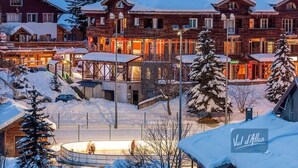 A snow-covered hotel with multiple buildings, a central courtyard, and a sign reading "Val d'Allos". - T2 Montagne Cosi Pied des Pistes- Piscine Hammam (Allos)