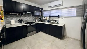 A modern kitchen with black cabinets, a gas stove, and a built-in oven.
