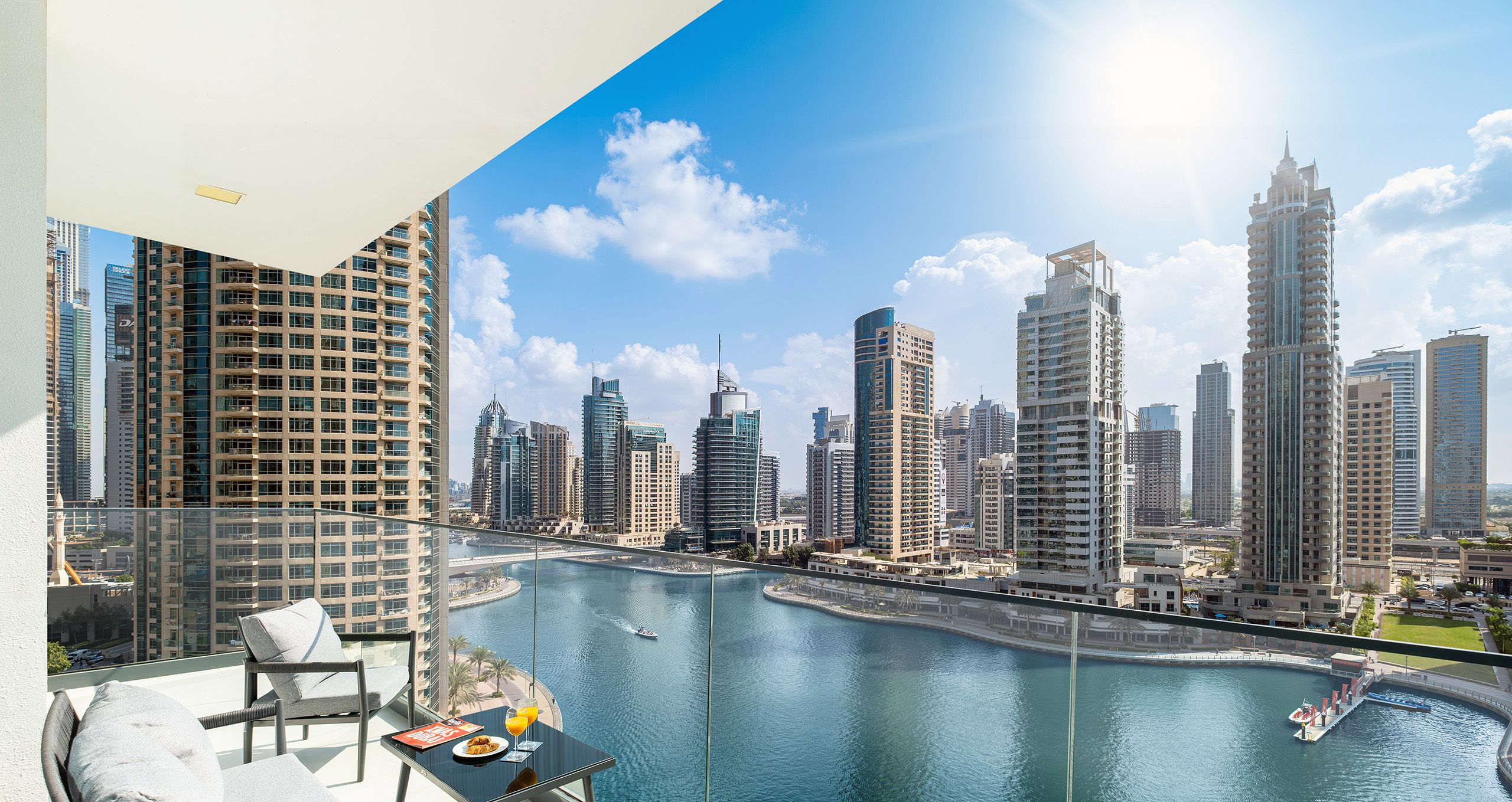 A balcony with a view of a city skyline and a body of water.
