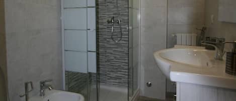 Habitación Confort | Baño | Regadera, secadora de cabello, bidet, toallas