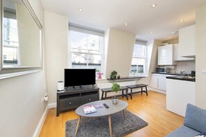 Eine moderne Wohnung mit Wohnbereich, Küche und Essplatz.