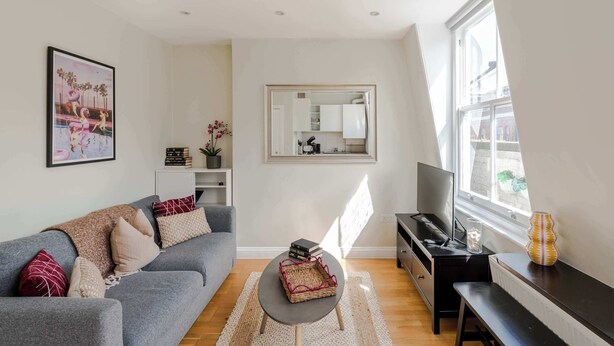 Una sala de estar moderna con un sofá gris, una mesita de centro, un televisor y un piano.