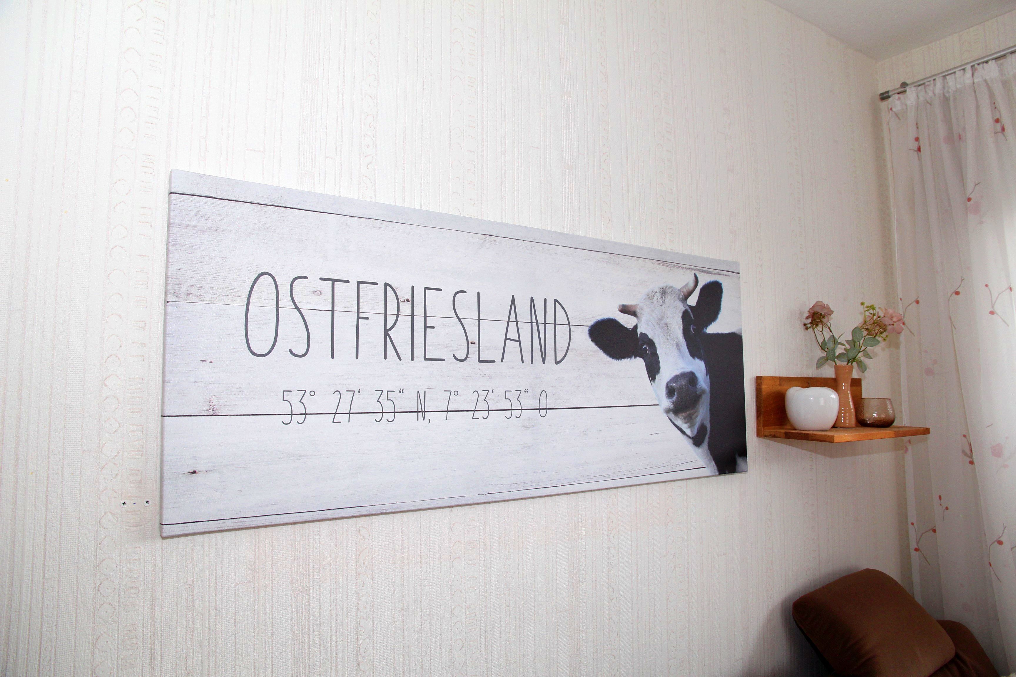 A wall with a sign reading "OSTFRIESLAND" and coordinates.