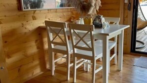 A wooden interior with a dining table and chairs, a mirror, and a potted plant. - Lazar House Ada Bojana (Ulcinj)